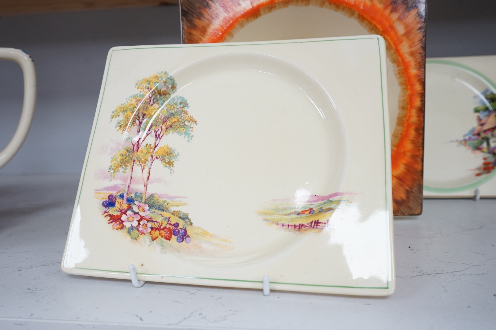 Three Clarice Cliff Bizarre ‘Biarritz’ dishes and a Wilkinson floral jug, largest 23cm wide